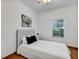 Bright bedroom features wood floors, a modern bed with a gray headboard, and a window with natural light at 2376 Park Village Pl, Apopka, FL 32712