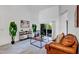 Bright living room with high ceilings, leather sofa, stylish shelving, and sliding glass doors to the outside at 2376 Park Village Pl, Apopka, FL 32712