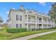 Two story building with light beige siding, dark gray shutters, and a wrap-around porch at 239 Longview Ave # 216, Celebration, FL 34747