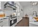 Stylish kitchen featuring white cabinets, a herringbone backsplash, and a dark range hood at 239 Longview Ave # 216, Celebration, FL 34747