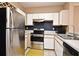The kitchen features stainless steel appliances and white cabinets with stylish backsplash at 2572 Robert Trent Jones Dr # 1231, Orlando, FL 32835