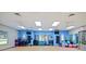 Bright aerobics room with blue accent wall, mirrors, and an array of exercise equipment at 26812 Augusta Springs Cir, Leesburg, FL 34748