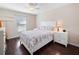 Cozy bedroom features a bed with floral bedding, dark wood floors and a nightstand with a lamp at 26812 Augusta Springs Cir, Leesburg, FL 34748