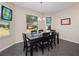 Dining room area features chandelier, dark table, and views of the backyard at 26812 Augusta Springs Cir, Leesburg, FL 34748