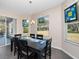 Dining room area features chandelier, dark table, sliding glass door, and views of the backyard at 26812 Augusta Springs Cir, Leesburg, FL 34748