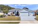 Charming single-story home featuring a well-manicured lawn, a two-car garage, and beautiful landscaping at 26812 Augusta Springs Cir, Leesburg, FL 34748
