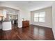 Open-concept living area with hardwood floors and view into the kitchen at 26812 Augusta Springs Cir, Leesburg, FL 34748