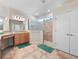 Spacious main bathroom featuring double vanity, walk-in shower with glass door, and tile floors at 26812 Augusta Springs Cir, Leesburg, FL 34748