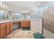 Spacious main bathroom featuring double vanity, walk-in shower with glass door, and tile floors at 26812 Augusta Springs Cir, Leesburg, FL 34748