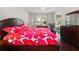 Main bedroom with dark wood floors and bold floral bedding, offering ample natural light and storage at 26812 Augusta Springs Cir, Leesburg, FL 34748