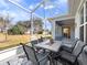 Screened lanai area with table, chairs, rug, and view of landscaped backyard at 26812 Augusta Springs Cir, Leesburg, FL 34748