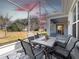 Outdoor living space: Screened lanai with table, chairs, rug, and view of landscaped backyard at sunset at 26812 Augusta Springs Cir, Leesburg, FL 34748