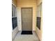 Front entry with brown door and small welcome mat at 3017 Cottage Grove Ct # Ge, Orlando, FL 32822