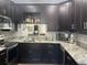 Modern kitchen with dark cabinetry, granite counters, and stainless steel appliances at 3017 Cottage Grove Ct # Ge, Orlando, FL 32822