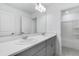 Well-lit bathroom with double sinks, gray cabinetry, and a shower/tub combo at 307 River Front Way, Edgewater, FL 32141