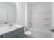 Neutral bathroom with gray vanity, bathtub-shower combo, and white toilet at 307 River Front Way, Edgewater, FL 32141
