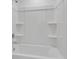 Bathroom features a large white bathtub, shower fixtures, and built in shelves at 307 River Front Way, Edgewater, FL 32141