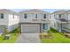 Two-story house with gray siding, stone accents, and a paved driveway at 3937 Lana Ave, Davenport, FL 33897