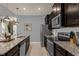 Modern kitchen with dark wood cabinets, stainless steel appliances, and granite countertops at 3937 Lana Ave, Davenport, FL 33897