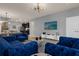 Open living room with blue velvet sofas and a view into the kitchen at 3937 Lana Ave, Davenport, FL 33897