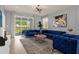Living room with blue velvet sofas, a large window, and access to the backyard at 3937 Lana Ave, Davenport, FL 33897