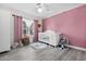Charming Bedroom with pink accent wall, crib, and ample natural light at 5011 Winwood Way, Orlando, FL 32819