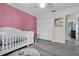 Bright Bedroom featuring a white crib, closet, and hardwood floors at 5011 Winwood Way, Orlando, FL 32819