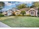House with a large lawn and mature trees at 5011 Winwood Way, Orlando, FL 32819