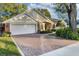 Brick and shingle home with a large driveway and lush landscaping at 5011 Winwood Way, Orlando, FL 32819