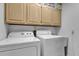 Neat laundry room with Whirlpool washer and dryer and upper cabinets at 5011 Winwood Way, Orlando, FL 32819