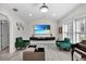 Elegant living room with hardwood floors, green velvet armchairs, and large TV at 5011 Winwood Way, Orlando, FL 32819