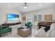 Living room with large TV, comfortable seating, and a piano at 5011 Winwood Way, Orlando, FL 32819