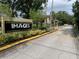 Community entrance with landscaping and building view at 5291 Images Cir # 204, Kissimmee, FL 34746