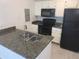 Kitchen with granite countertops and black appliances at 5291 Images Cir # 204, Kissimmee, FL 34746