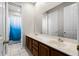 Bathroom featuring double sinks with wood cabinets and a tub with blue gradient shower curtain at 1108 Darnaby Way, Orlando, FL 32824