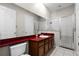 Bathroom with wood cabinets, red countertop, and shower at 1108 Darnaby Way, Orlando, FL 32824