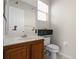 Cozy bathroom with wooden vanity, sink, toilet, and cabinet space at 1108 Darnaby Way, Orlando, FL 32824