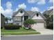 Two-story home with a stone veneer, tan stucco, a two-car garage, and attractive landscaping at 1108 Darnaby Way, Orlando, FL 32824