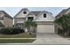 Charming two-story home featuring a well-manicured lawn, a brick-paved driveway, and stone veneer at 1108 Darnaby Way, Orlando, FL 32824
