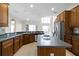 Spacious kitchen features wood cabinetry, an island, stainless steel appliances, and tile floors at 1108 Darnaby Way, Orlando, FL 32824