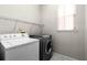 Bright laundry room features modern washer and dryer with built-in shelving and a window at 1108 Darnaby Way, Orlando, FL 32824