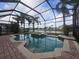 Beautiful screened-in pool and spa with serene pond views and tropical palm trees at 1108 Darnaby Way, Orlando, FL 32824