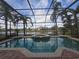 Screened-in pool with spa overlooking a scenic pond and lush landscaping at 1108 Darnaby Way, Orlando, FL 32824