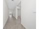 Long hallway with tile floors and access to different rooms at 1213 Red Hill Rd, Davenport, FL 33837
