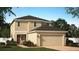 Two-story house with a two-car garage and landscaped front yard at 1223 Island Slough Ln, Davenport, FL 33837