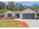 Updated home exterior boasts a gray and white color scheme, landscaping, and a two-car garage at 1395 Kenneth Ave, Casselberry, FL 32707