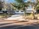 White mid-century modern home with large windows, mature trees, and a long driveway at 1642 Athens St, Lakeland, FL 33803