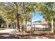 Mid-century home nestled among lush trees, showcasing a brick facade and carport at 1642 Athens St, Lakeland, FL 33803