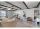 Living room with L-shaped sofa, wood beams, and view into Gathering room at 1642 Athens St, Lakeland, FL 33803