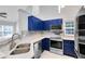 Modern kitchen with blue cabinets, quartz counters, and stainless steel appliances at 3433 Soho St # 204, Orlando, FL 32835